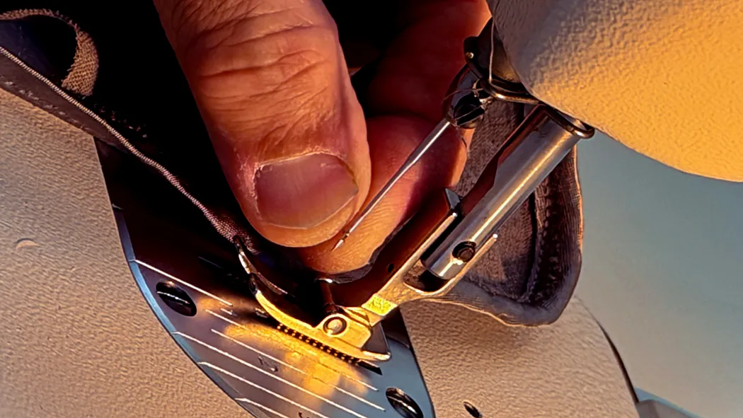Close on the presser foot as a zip is stitched into a garment