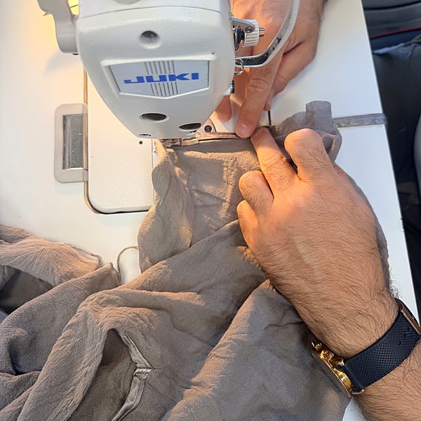 Hands guiding fabric through the JUKI industrial machine at our Nine Elms shop